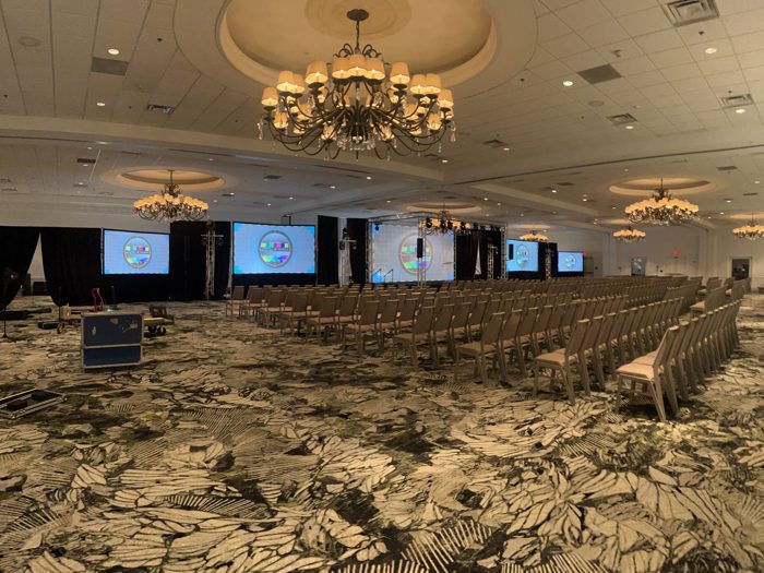 Rows of chairs facing a calibrated stage screen