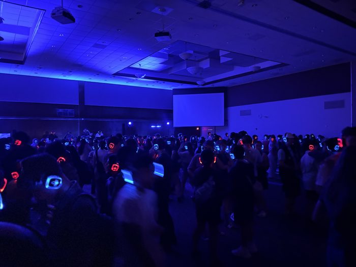 Silent disco crowd wearing glowing headphones